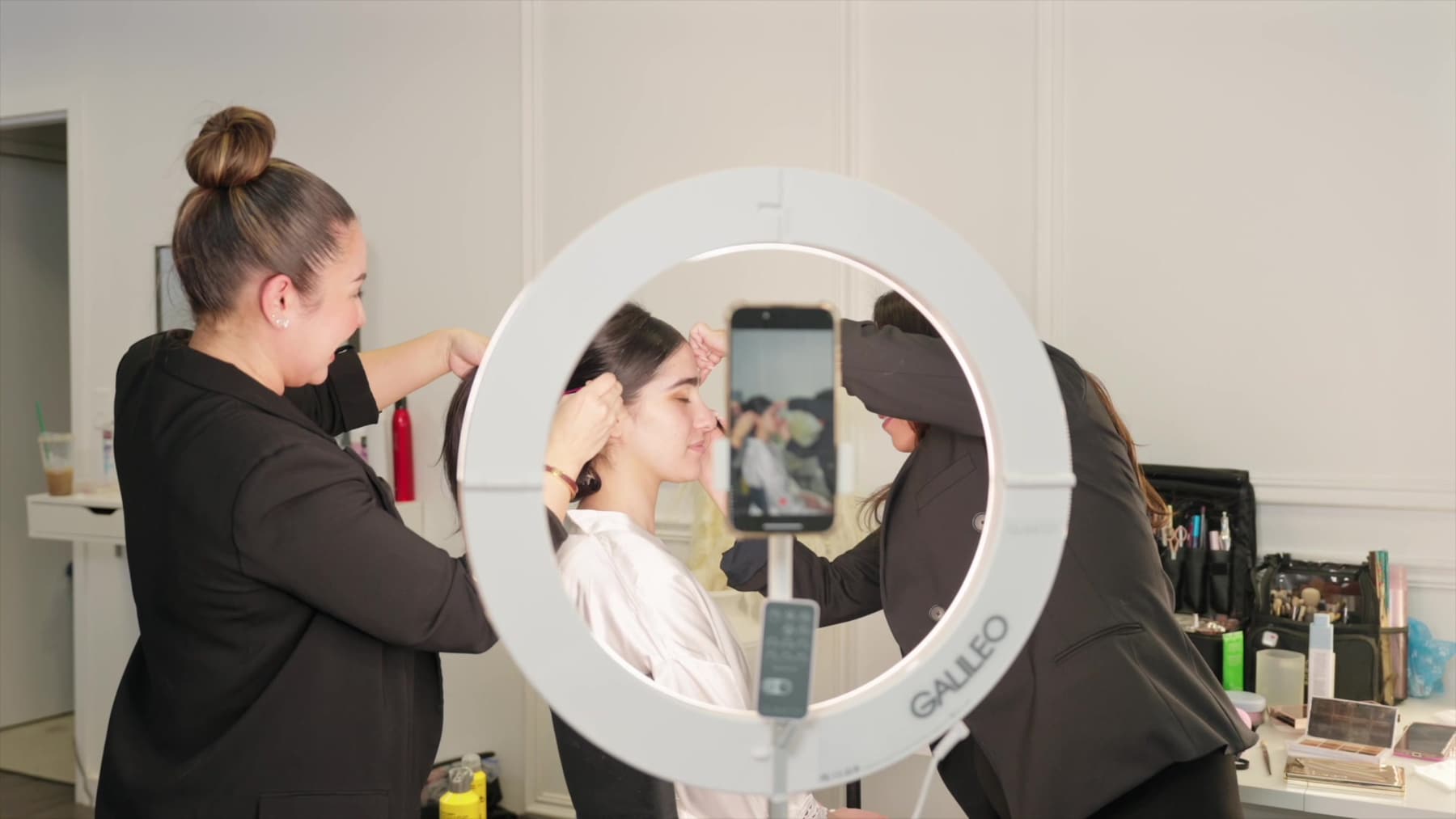 Two people working around a lit GALILEO ring, a phone in the center